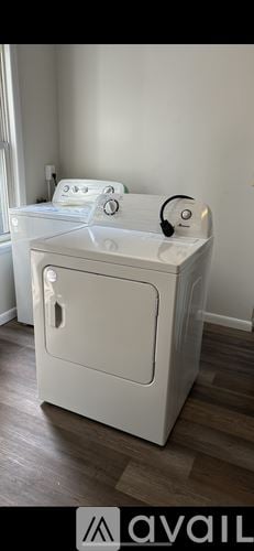 Scranton house for rent - A white washing machine is placed in a room with wooden flooring.
