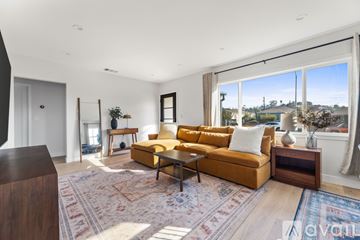 Los Angeles house for rent - A living room with a yellow couch and a rug.