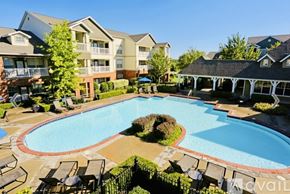 Fayetteville house for rent - A large swimming pool surrounded by lounge chairs and apartment buildings.
