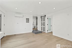 Los Angeles apartment for rent - A spacious room with wooden flooring and white walls.