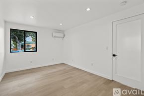 Los Angeles apartment for rent - A room with a white door and a window with a view of a building and trees.