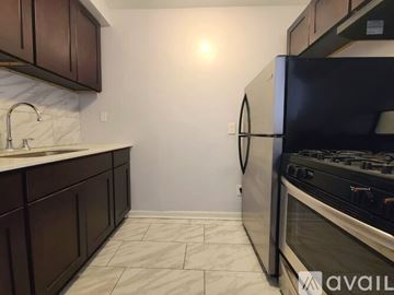 Newark apartment for rent - A kitchen with a black fridge and a black stove.
