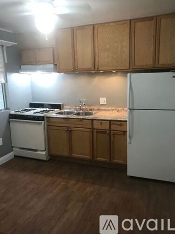 El Cajon house for rent - A kitchen with wooden cabinets and a white fridge.
