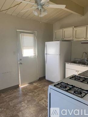 El Cajon house for rent - A kitchen with a white fridge, stove, and cabinets.