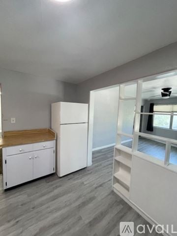 Sarasota apartment for rent - A kitchen with white cabinets and a wooden countertop.