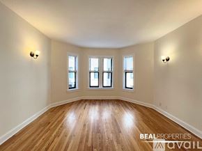 Chicago apartment for rent - A room with wooden floors and three windows.
