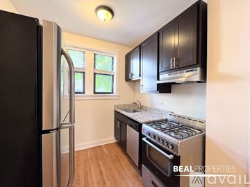 Chicago apartment for rent - A kitchen with black cabinets and a stainless steel refrigerator.
