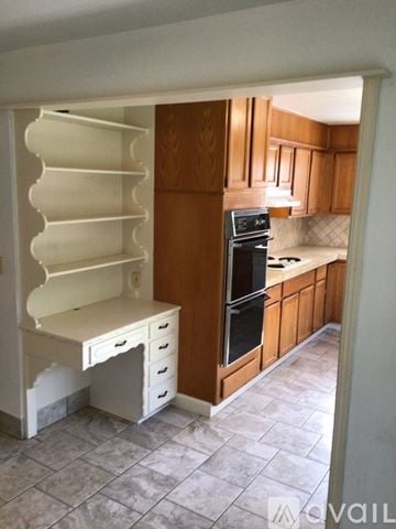 Edmond house for rent - A kitchen with wooden cabinets and a black stove top oven.