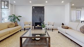 Toronto (St. Andrew-Windfields) house for rent - A living room with a fireplace and a glass coffee table.