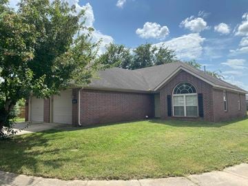 Rogers house for rent - A house with a brick exterior and a large front yard.
