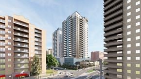 Saskatoon apartment for rent - A city street with apartment buildings on either side and a large building in the middle.