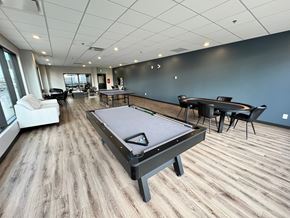 Saskatoon apartment for rent - A billiard table is in the middle of a room with a pool table and a ping pong table.