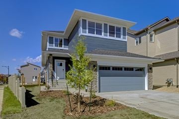 Edmonton apartment for rent - A modern house with a grey garage door and a white door.