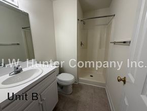 Wilson apartment for rent - A bathroom with a toilet, sink, and bathtub.