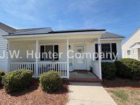 Wilson apartment for rent - A white house with a porch and a sign that says J.W. Hunter Company.