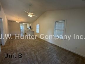 Wilson apartment for rent - A spacious room with a ceiling fan and a window with blinds.