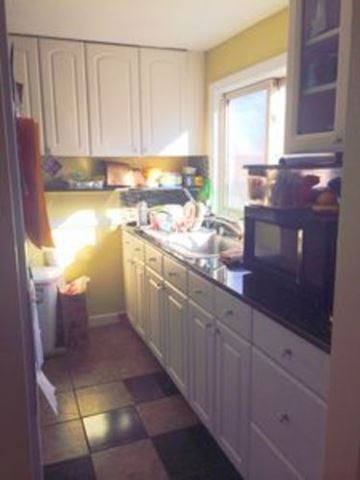 Arlington house for rent - A kitchen with white cabinets and a black and white checkered floor.