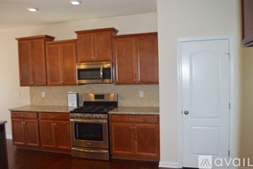 Concord house for rent - A kitchen with wooden cabinets and a stainless steel oven.