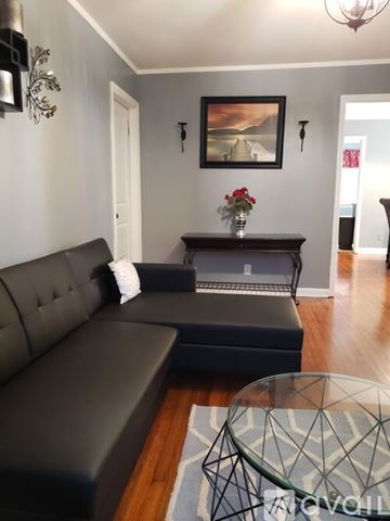 Macon house for rent - A living room with a grey couch and a glass coffee table.