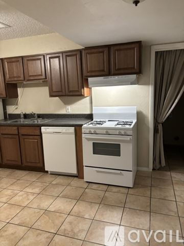 Bethany house for rent - A kitchen with a white stove and brown cabinets.