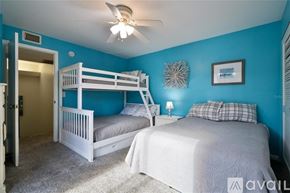New Smyrna Beach townhouse for rent - A bedroom with two beds and a ceiling fan.