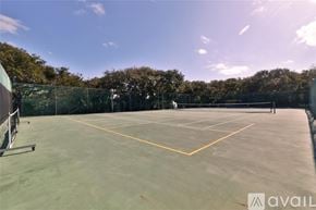 New Smyrna Beach townhouse for rent - A tennis court with a net and trees in the background.