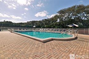 New Smyrna Beach townhouse for rent - A large outdoor swimming pool surrounded by a brick patio.