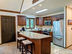 Dillard house for rent - A kitchen with a refrigerator, stove, and bar stools.