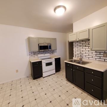 Williamsport apartment for rent - A kitchen with black and white tiles and white appliances.