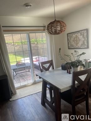 River Falls townhouse for rent - A dining room with a table and chairs and a hanging light fixture.