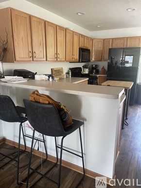 River Falls townhouse for rent - A kitchen with a white counter top and black barstools.