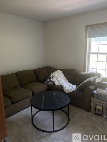 River Falls townhouse for rent - A living room with a brown couch and a black coffee table.