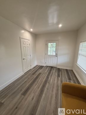 Los Angeles apartment for rent - A room with a yellow chair and wooden flooring.