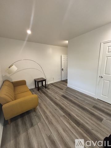 Los Angeles apartment for rent - A living room with a yellow couch and a wooden floor.