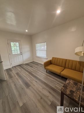 Los Angeles apartment for rent - A living room with a yellow couch and wooden flooring.