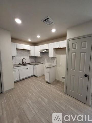 San Antonio apartment for rent - A kitchen with white cabinets and a grey door.