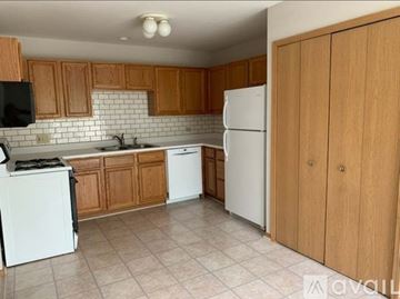 Crystal Lake condo for rent - A kitchen with wooden cabinets and white appliances.