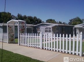 El Cajon house for rent - A white picket fence surrounds a row of houses.