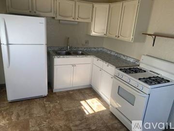 El Cajon house for rent - A kitchen with a white fridge, white oven, and white cabinets.