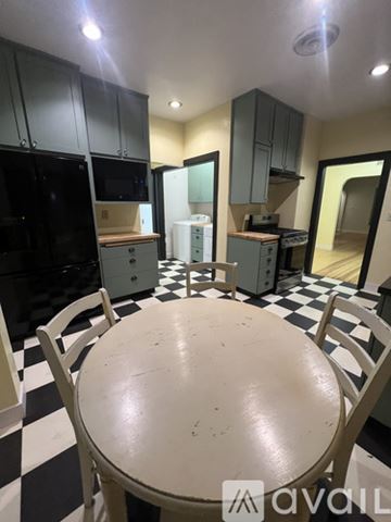 Gridley house for rent - A kitchen with black and white checkered floor and a table in the middle.