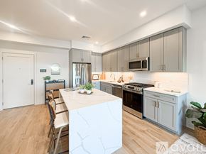 Boston apartment for rent - A modern kitchen with a white marble island and wooden floors.