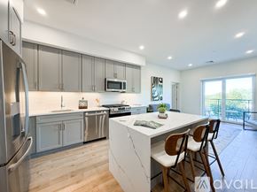 Boston apartment for rent - A kitchen with a white island and wooden chairs.