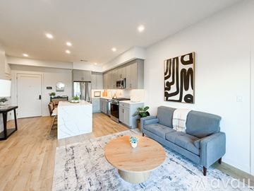 Boston apartment for rent - A modern living room with a grey couch and a wooden coffee table.
