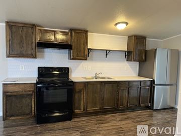 Odessa house for rent - A kitchen with wooden cabinets and a black stove top oven.