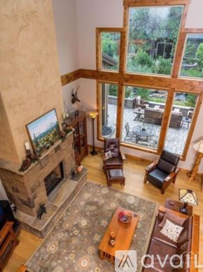 Bend townhouse for rent - A living room with a fireplace and a view of the backyard.