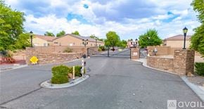 Bullhead City house for rent - A street view of a residential area with houses and a gated entrance.