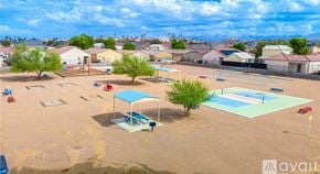 Bullhead City house for rent - An aerial view of a playground with a blue shade structure and a swimming pool.