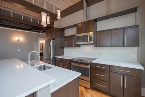 Pittsfield apartment for rent - a kitchen with white counter tops and wooden cabinets