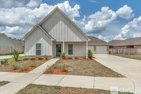 Brandon house for rent - A modern house with a grey exterior and a large front yard.