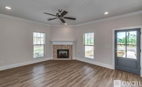 Brandon house for rent - A spacious room with a fireplace and a ceiling fan.